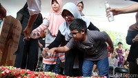 Istri dan kedua anak Asep Fajar menaburkan bunga di pusara Asep Rahmat Fajar.