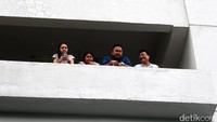 Empat orang warga menonton demo driver GrabBike dari atas gedung.