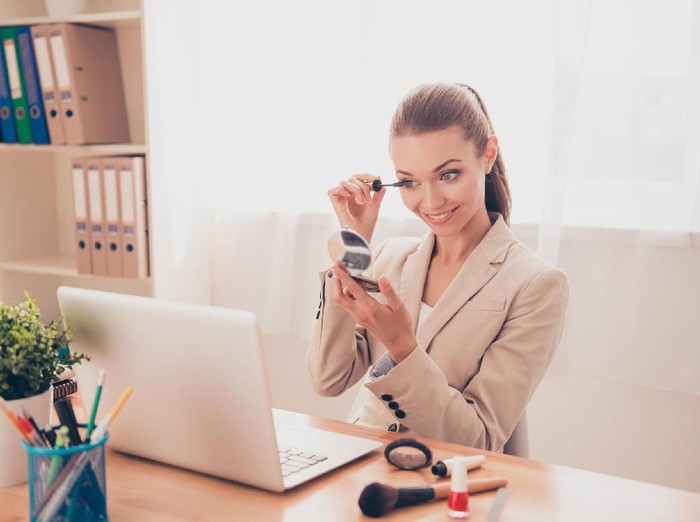 621481834 Portrait of pretty businesswoman painting her eyelashes with mascara