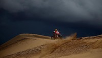 Langit hitam karena mendung mnggelayut di atas kepala Gregorio Caselani (Brasil) saat menggeber CRF450 Rally Honda tunggangannya. (Foto: Dan Istitene/Getty Images)