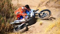 Kevin Echeveste (Argentina) memperbaiki motor 450 Rally Husqvarna miliknya yang mengalami kerusakan. Tercatat ada 143 pebalap motor yang berpartisipasi dalam event tahun ini (Foto: Dan Istitene/Getty Images)