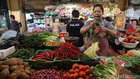 Seorang pedagang melayani pembeli.