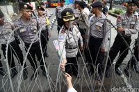 Dibatasi Pagar Berduri, Ibu Ini Beri Bunga ke Polisi