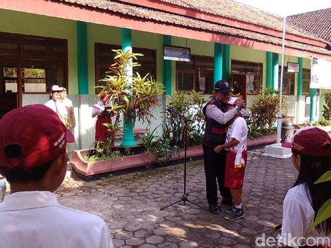 Bripka Arifin dipeluk anak SD yang saat itu jadi pimpinan upacara