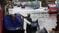 Seorang pedagang es mengantarkan dagangannya.