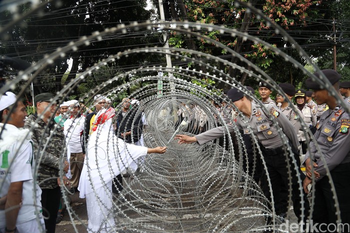 Dibatasi Pagar Berduri, Ibu ini Beri Bunga ke Polisi