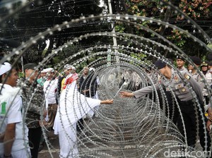 Dibatasi Pagar Berduri, Ibu ini Beri Bunga ke Polisi