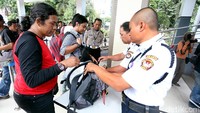 Petugas keamanan memeriksa barang bawaan Pewarta Foto Indonesia (PFI) sebelum masuk ke Mapolda Metro Jaya.