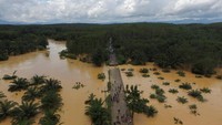 Sebuah jembatan yang menghubungkan ruas jalan raya bagian utara dan selatan Thailand, terputus usai beberapa bagian hanyut terbawa arus banjir yang deras. Dailynews/ via REUTERS.