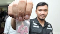 Seorang petugas menunjukkan barang bukti di Mapolda Metro Jaya.