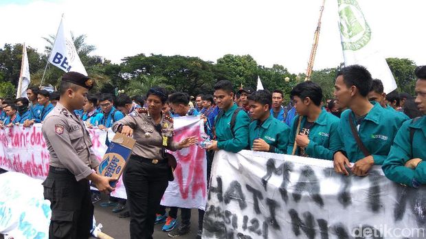Anggota Polwan membagikan air minum ke massa
