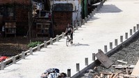 Seorang warga bersepeda di jalan inspeksi Kalibata yang tengah dibangun.