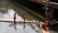 Sampah-sampah yang tersangkut ini kemudian dipindahkan oleh petugas.