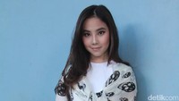Ia memadukan celana jeans dengan atasan putih dan balutan syal bergambar tengkorak. Hanif Hawari/detikHOT