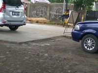 Besi menonjol di pertemuan antara jalan yang sudah dibeton dan yang masih rusak
