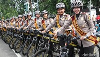 Para Polwan bersepeda berpose dengan senyum ramah dan simpatik.