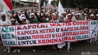 Massa FPI berorasi sambil membentangkan spanduk tuntutan.