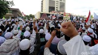Massa FPI berorasi sambil mengepalkan tangan bersama.