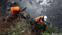 Pasukan oranye nyemplung ke sungai untuk membersihkan lumpur, Selasa (17/1).