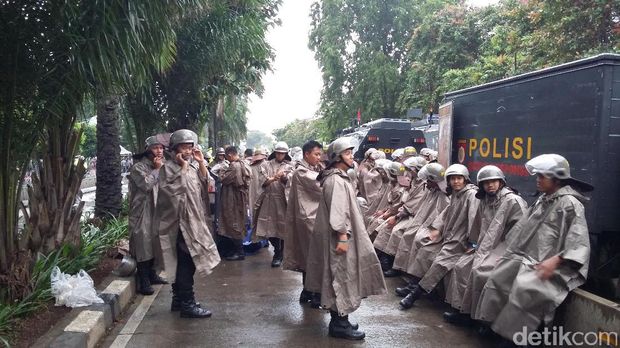 Polisi membawa tameng dan tongkat.