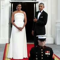 Barack Obama mengacungkan jempol pada Michelle yang anggun berbalut gaun putih strapless minimalis karya Brandon Maxwell. (Foto: Getty Images)