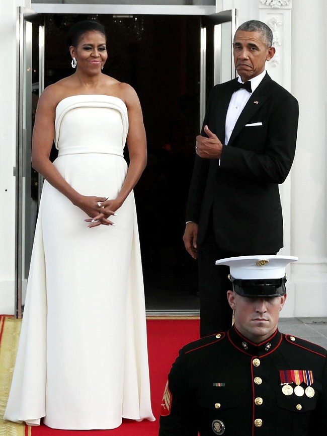 Barack Obama mengacungkan jempol pada Michelle yang anggun berbalut gaun putih strapless minimalis karya Brandon Maxwell. (Foto: Getty Images)