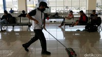 Petugas kebersihan tengah membersihkan ruang tunggu di dalam terminal.