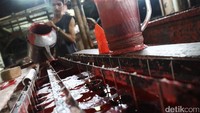 Pekerja menuangkan adonan lilin.
