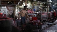 Para pegawai berjibaku dengan bahan pembuat lilin, dan mencetaknya dalam ukuran-ukuran besar.