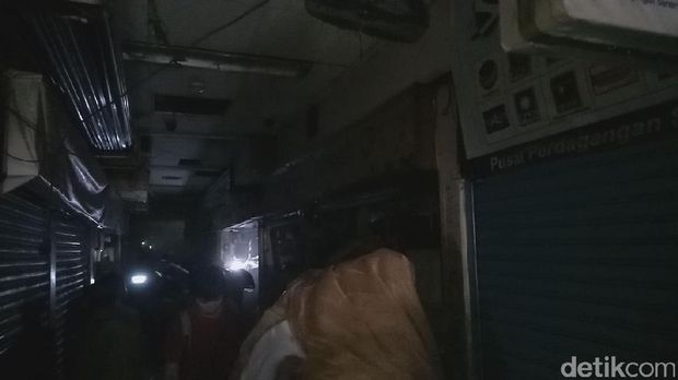 Pedagang menyelamatkan dagangan di lantai dasar Pasar Senen.