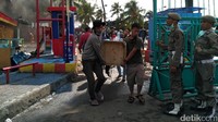Para pedagang mengevakuasi barang dagangan dengan pengawasan Satpol PP.