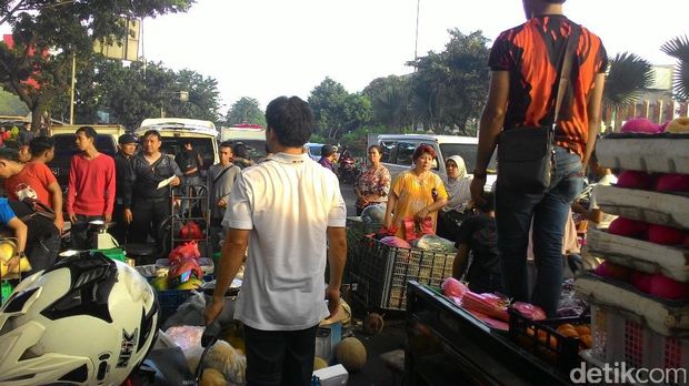 Pedagang menyelamatkan barang-barang mereka di jalanan.