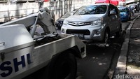 Mobil yang parkir sembarangan tersebut mengakibatkan jalan macet sehingga diderek.