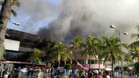 Warga berkerumun di sekitar pasar yang terbakar.