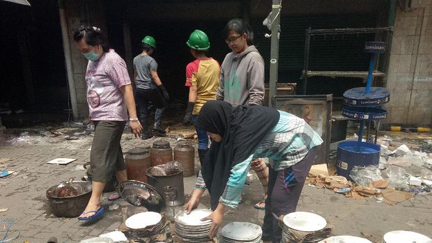 Warga lainnya juga membantu pedagang memilah-milah dan membersihkan dagangan yang rusak
