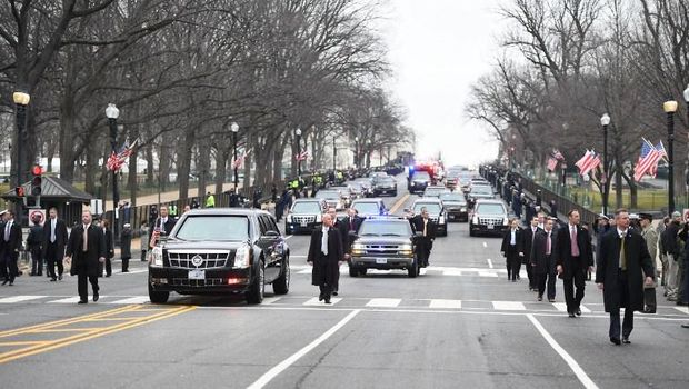 The presidential limousine leaves Capitol Hill grounds and drives up Pennsylvania Avenue to the White House surrounded by security detail after inauguration ceremonies for US President Donald Trump on January 20, 2017 in Washington, DC. / AFP PHOTO / JIM WATSON