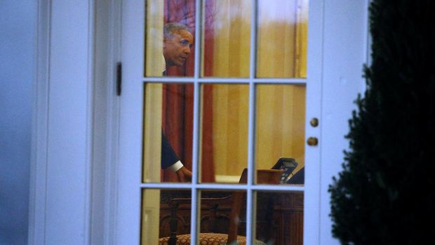 Barack Obama terlihat meletakkan secarik surat di meja dalam momen terakhirnya di Ruang Oval