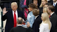 Donald Trump disumpah untuk menjadi Presiden Amerika Serikat dengan disaksikan istri dan anaknya. Kevin Lamarque/Reuters/detikFoto.