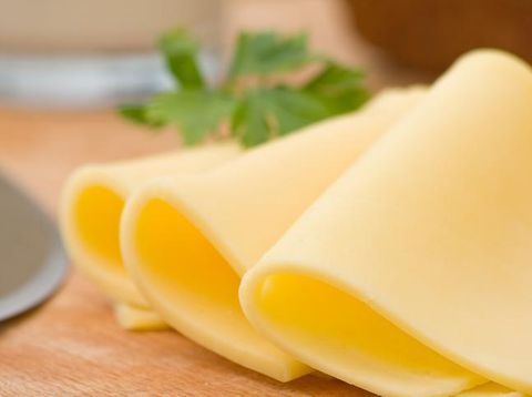 Sliced delicious edam cheese on wooden board with selective depth of field