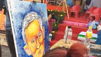 Penyandang tuna daksa ini hanya menggunakan mulut untuk melukis sosok Raja Bhumibol Adulyadej. Bisa dibeli juga berbagai karyanya untuk oleh-oleh (Andi Annisa/detikTravel)