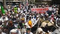 Mereka berkumpul di dekat Halte TransJakarta Polda Metro. Sebagian di antaranya duduk dan ada pula yang berteduh di jembatan halte.