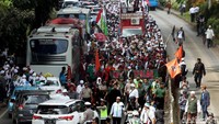 Massa bergerak berlawanan arah dari jalur kendaraan.