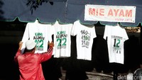 Mereka memamerkan kaos dagangannya.