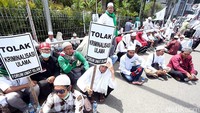 Massa membentangkan poster di depan Polda Metro Jaya.