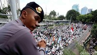 Seorang polisi memantau kumpulan massa FPI.