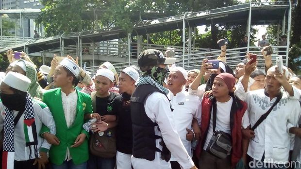  Massa FPI membentuk barikade mengawal kedatangan Habib Rizieq di Mapolda Metro Jaya, Senin (23/1/2017)