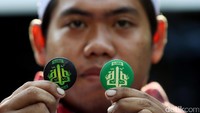 Salah seorang massa FPI memamerkan pin bertuliskan Alumni 212 Aksi Bela Islam di halaman Masjid Al-Azhar, Senin (22/1/2017).