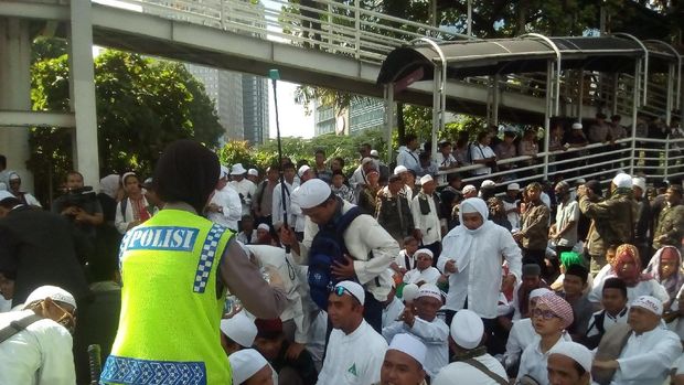 Polwan membagi-bagikan air mineral kepada massa FPI,