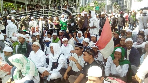 Massa FPi duduk-duduk menanti pemeriksaan Habib Rizieq.