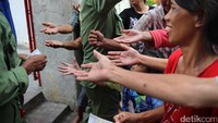Pengemis berebut uang receh yang dibagikan oleh jemaat vihara. Jumlah pengemis akan membludak pada hari Imlek.
